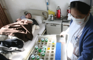A nurse giving drugs to a patient with MDR-TB
